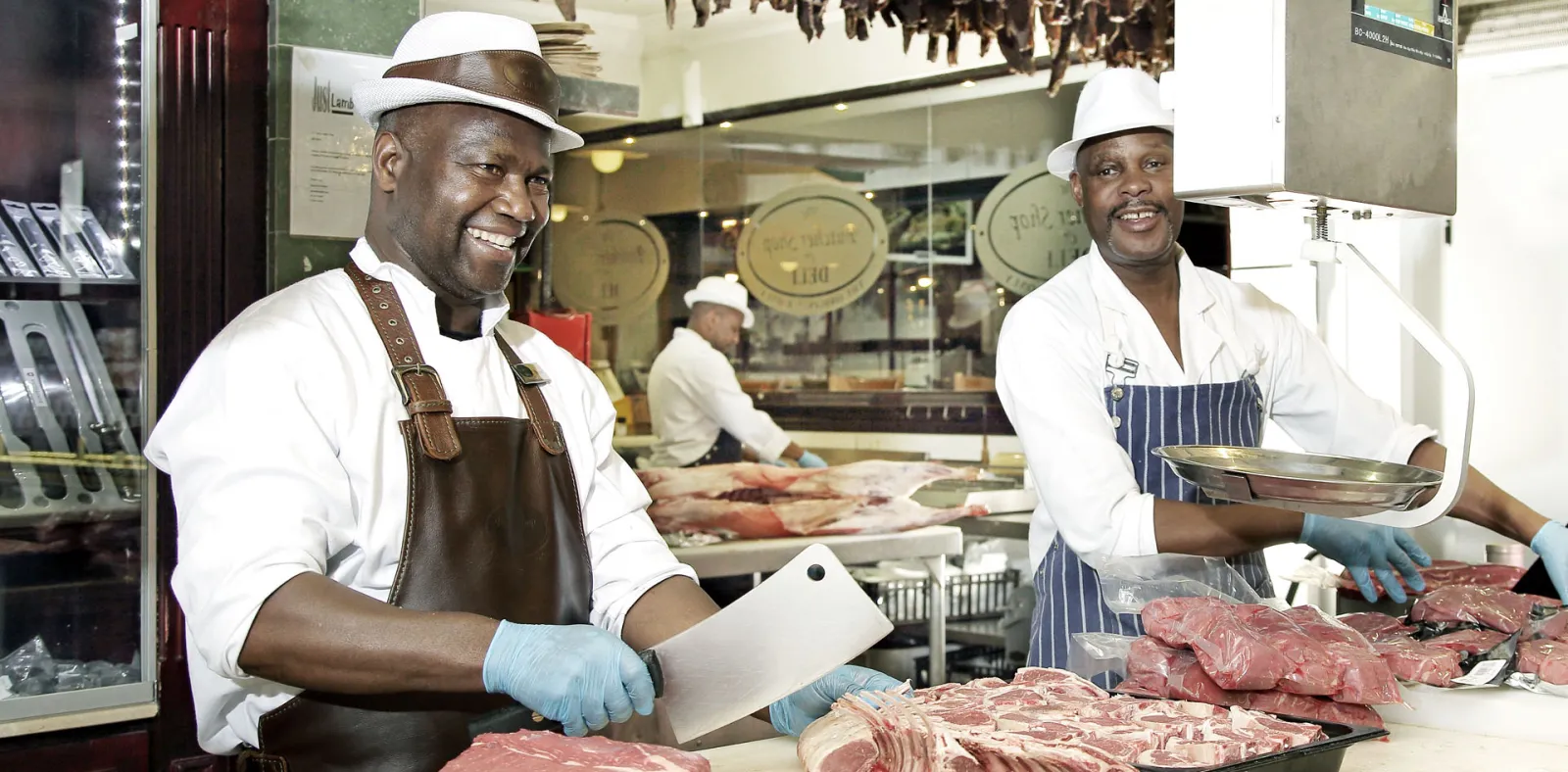 Two butchers in whites and aprons at the butchery counter