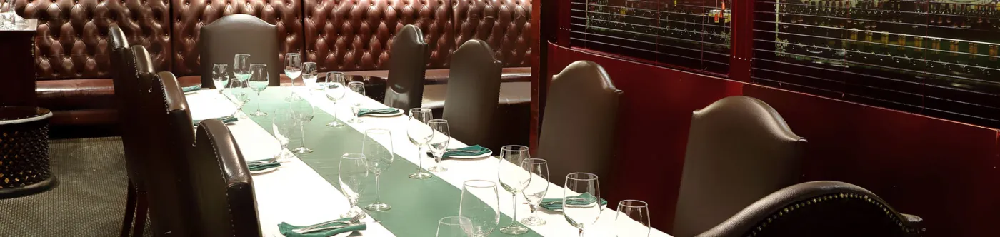 A private dining room with a long table and leather chairs